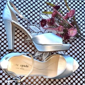 Kate Spade white satin, open-toe platform pumps.